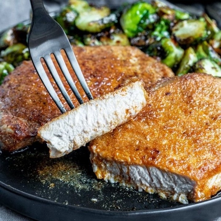 A crispy pork chop with a tender, white meat interior.